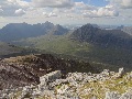 (4) A typical Torridon hill is mainly Torridonian sandstone - a rich brown with hints of red and purple, well layered, and very hard.  Most of the highest hills are topped by light-coloured quartzite. The two types of rock are well contrasted here, looking north from the top of Mullach an Rathain, Liathach's western summit, to Beinn Dearg and Beinn Alligin.  July.