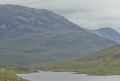 
	Torridonian strata fanning out on the east of Beinn h'Eaglaise behind
	Lochan Neimhe, viewed from the path.  Beinn Damph is poking up to
	its right.  A view early in the day.
	