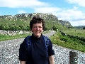 Walk's end:  Clare back at the road, with the limestone
		cliffs of Stronechrubie to the south